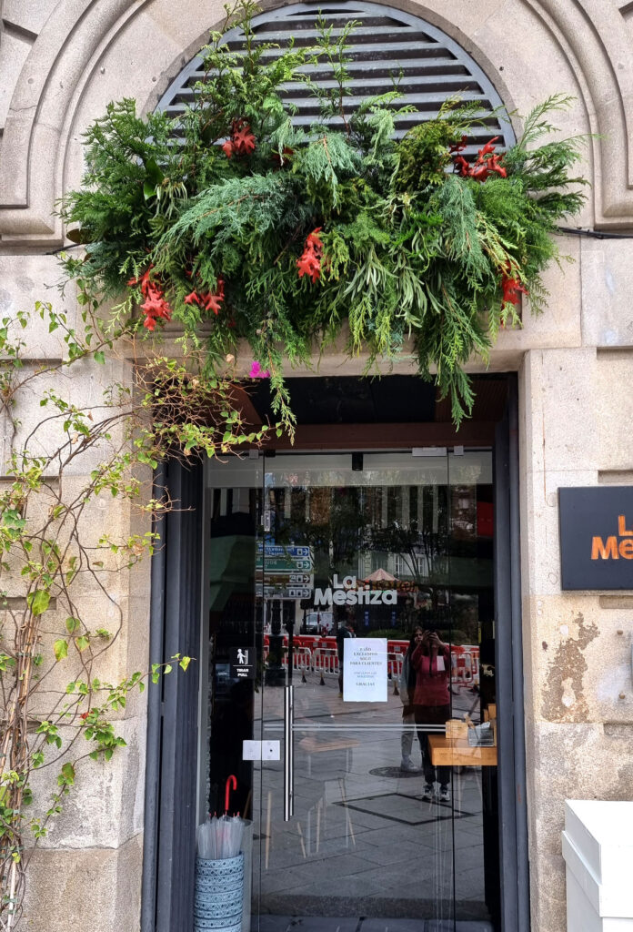 arreglo floral navideño sobre la entrada del local de un negocio