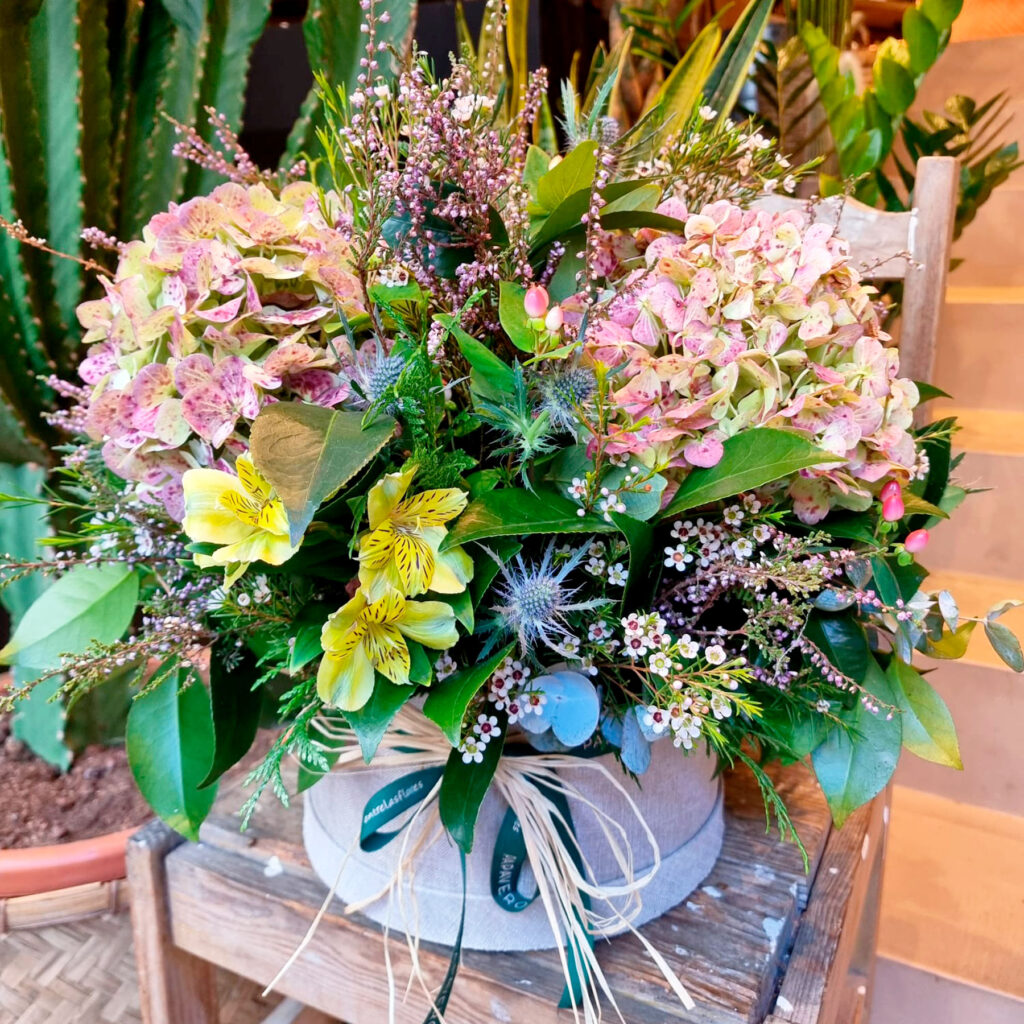 flores frescas de temporada en una sombrerera de tamaño grande