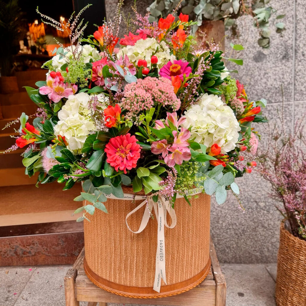 flores frescas de temporada en una sombrerera de madera de tamaño grande
